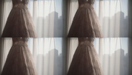 豪华现代婚纱挂在窗口。时尚的粉彩婚礼礼服蕾丝花的细节高清在线视频素材下载