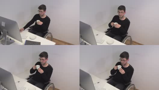 坐着轮椅的办公室职员，深色头发的女人在电脑旁边的工作场所喝咖啡，慢镜头高清在线视频素材下载