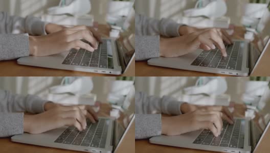 在家里的笔记本电脑上打字的女人亚洲人的手和早晨的阳光，年轻女孩的手的特写高清在线视频素材下载