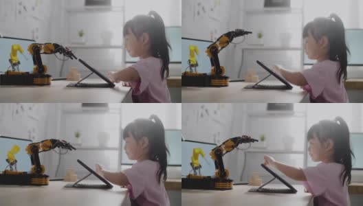 女孩在数字平板电脑上控制机器人手臂，在高中上机器人课高清在线视频素材下载