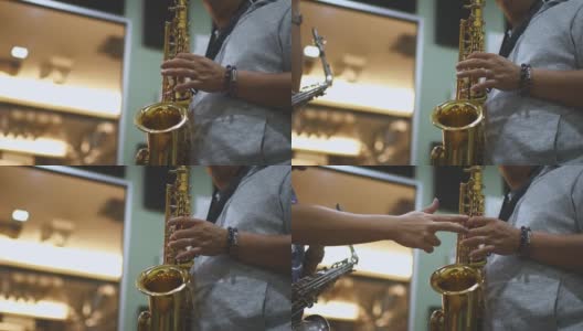 低角度近距离拍摄亚洲华人中年男子学习乐器演奏萨克斯，从他的导师在音乐工作室高清在线视频素材下载