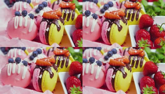 马卡龙手工制作的精美甜品，用新鲜草莓和蓝莓装饰的巧克力甜点，精致的黄色和粉色蛋糕，糖和健康食品高清在线视频素材下载