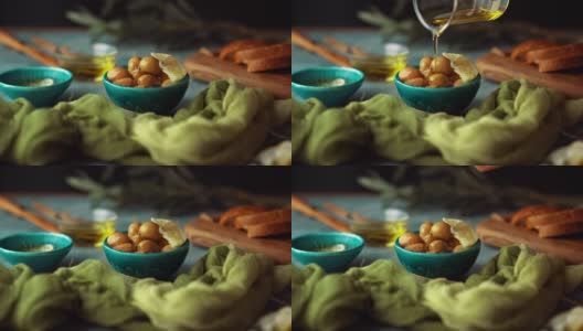 向绿橄榄、迷迭香、面包中倒入橄榄油高清在线视频素材下载