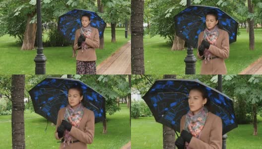 年轻悲伤的女人在雨中漫步在公园里。高清在线视频素材下载