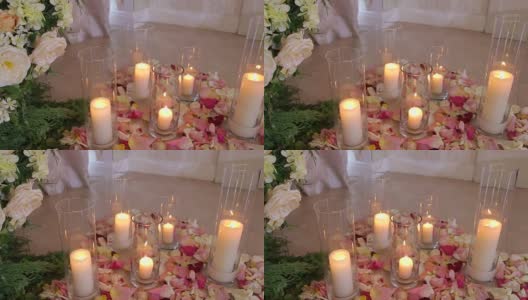玫瑰花瓣间的玻璃瓶里的蜡烛。婚礼高清在线视频素材下载
