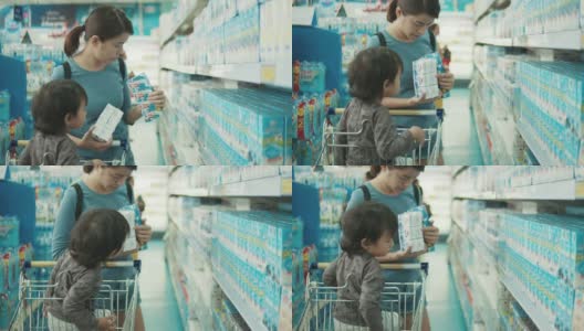 年轻迷人的妈妈和小孩在超市买食物。高清在线视频素材下载