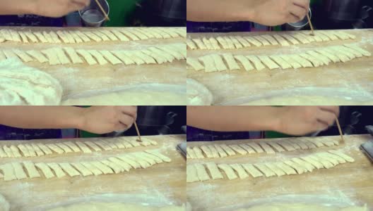 Seller hand prepare of fried bread stick, the bread is also popularly known as Cakoi, a popular Chinese cuisine.高清在线视频素材下载
