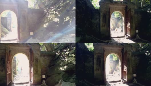 路过古老的石门和年轻的女士从山洞走出来高清在线视频素材下载