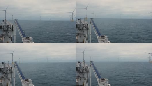 从转运船(船，码头)的平台上看，漂浮在风力发电机，蓝色波浪的海和穆迪。起重机和甲板上的视图。高清在线视频素材下载