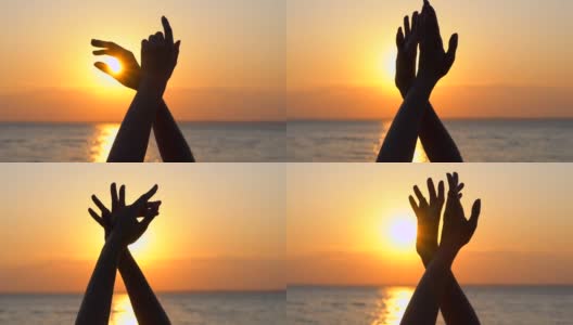 女孩用她的手臂跳舞到天堂的背景在海面上，海洋的海滩外面的水在日出或日落近太阳夏天自然手舞舞者快乐的节日，慢动作高清在线视频素材下载