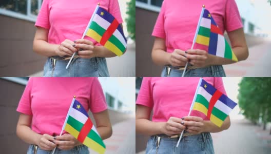 拿着中非国旗的陌生女子。女孩举着中非共和国国旗走在大街上高清在线视频素材下载