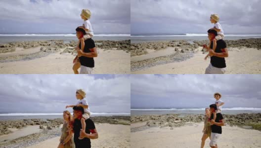 父亲带着儿子沿着海滩散步高清在线视频素材下载
