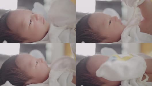 靠近宝宝的脸，亚洲妈妈准备给0-1个月的宝宝换尿布。高清在线视频素材下载