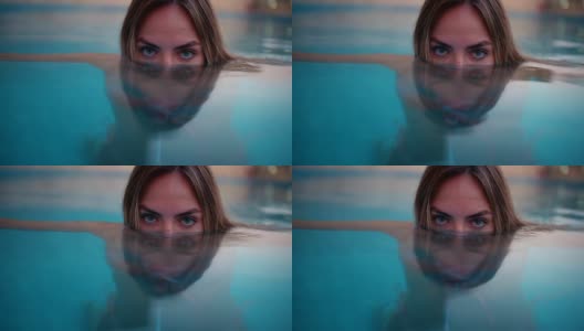 一个蓝眼睛的年轻女子在游泳池里高清在线视频素材下载