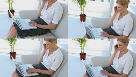 女商人坐着用笔记本电脑打电话高清在线视频素材下载