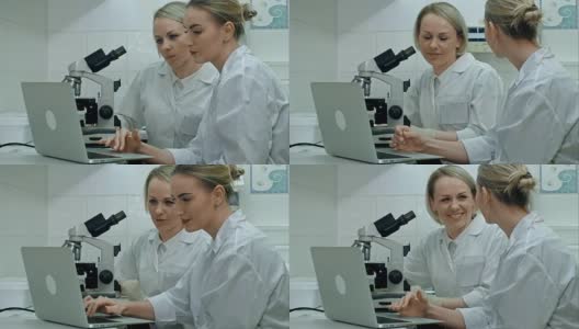 两位年轻的积极科学家在实验室使用显微镜和笔记本电脑工作高清在线视频素材下载
