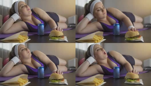 快乐自信的肥胖女孩吃油腻的汉堡而不是运动锻炼高清在线视频素材下载