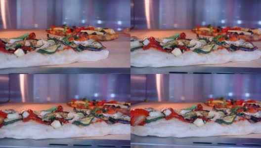 几种不同馅料的披萨在烤箱里烤熟。特写镜头高清在线视频素材下载