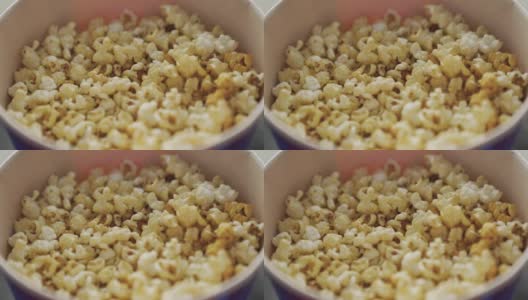 甜爆米花在桶里的特写。媒体。在电影院看电影的美味的甜爆米花。在电影院吃甜点。电影院的传统爆米花高清在线视频素材下载
