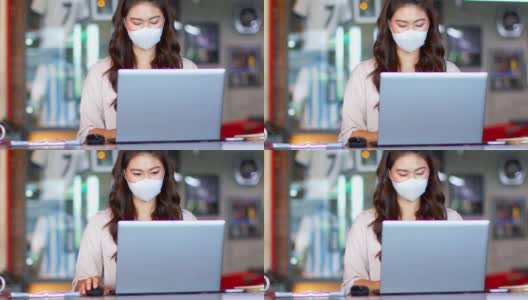 亚洲女性戴着外科口罩，用笔记本电脑思考，在现代办公室或联合办公空间创业，以获得想法和要求的新常态高清在线视频素材下载