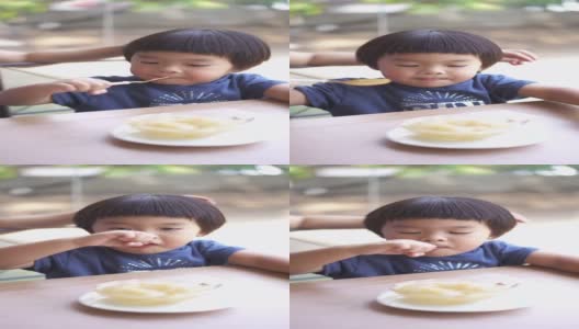 一个亚洲男婴和母亲在餐厅吃甜点的垂直镜头高清在线视频素材下载