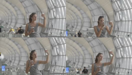 一名女子在机场候机楼用手机自拍。肖像高清在线视频素材下载