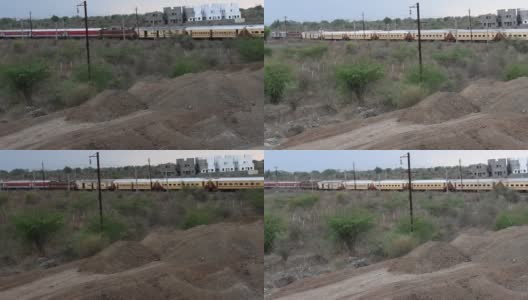 两辆黄色和红色的印度火车在相反的方向经过。高清在线视频素材下载