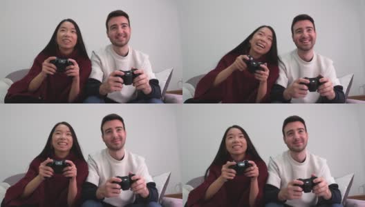 年轻的多种族夫妇玩电子游戏的乐趣。高清在线视频素材下载