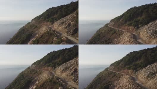 鸟瞰图的摩托车驾驶在危险的海岸悬崖边的道路。高清在线视频素材下载
