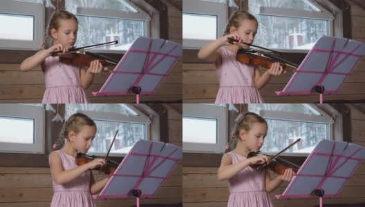 小女孩在家里拉小提琴和锻炼身体高清在线视频素材下载