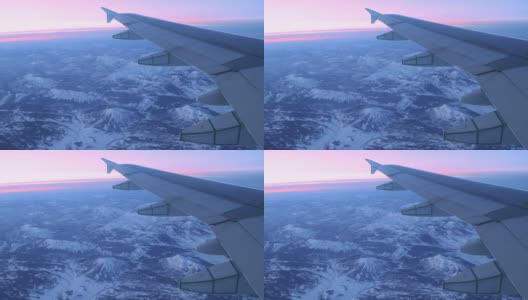 日出日落时，飞机飞过多雪的岩石山脉高清在线视频素材下载