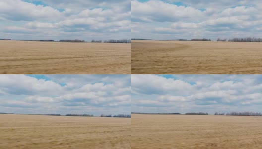 一辆快速行驶的汽车窗外的景色。早春耕地，蓝天白云。农业用地。POV 3轴稳定视频高清在线视频素材下载