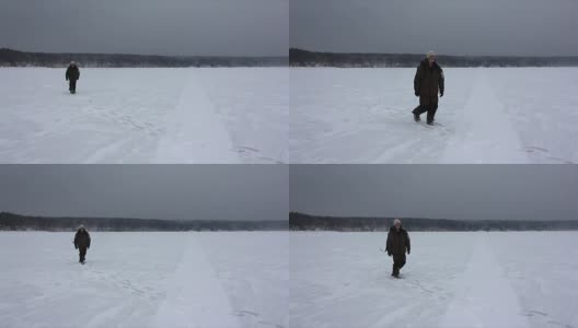 俄罗斯鄂毕河水库，一名背着背包的男子在暴风雪中行走高清在线视频素材下载