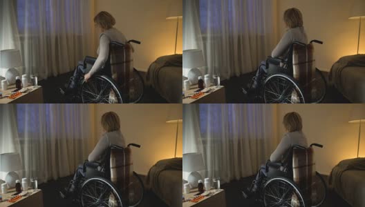 坐在轮椅上的残疾妇女看着窗外的街道，孤独高清在线视频素材下载