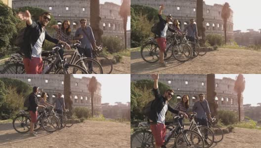 三个快乐的年轻朋友游客与自行车和背包在罗马斗牛场挥手，在山上的日落与树木的慢镜头娱乐高清在线视频素材下载