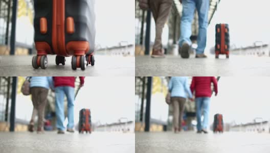 双腿的特写镜头沿着火车站的站台走，一个手提箱正在附近被抬着高清在线视频素材下载