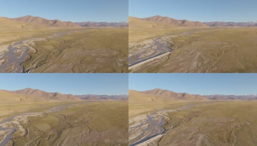 航拍:沿着流经喜马拉雅干旱平原的小溪飞行。高清在线视频素材下载