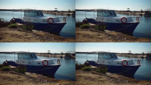 蓝天下，小船停泊在海湾肮脏的海滩上高清在线视频素材下载