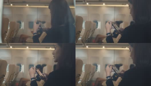 亚洲女性乘客在飞机上使用智能手机，从飞机窗外看高清在线视频素材下载