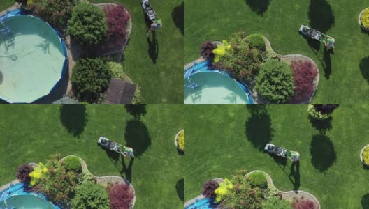 一个人在一个巨大的院子里用割草机割草。高清在线视频素材下载