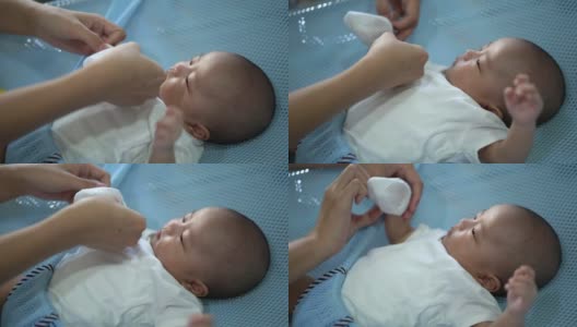 母亲为儿子戴着婴儿连指手套高清在线视频素材下载
