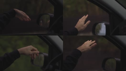 一个男人的手正在捕捉雨在一个雨天开车，慢动作高清在线视频素材下载