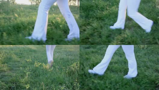 人类的腿。走在草地上的女人。高清在线视频素材下载
