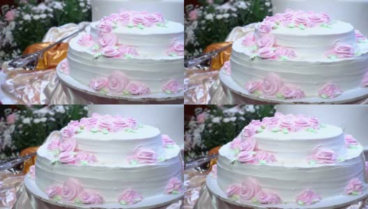 镜头:美丽的婚礼蛋糕，在婚宴上装饰着鲜花。高清在线视频素材下载