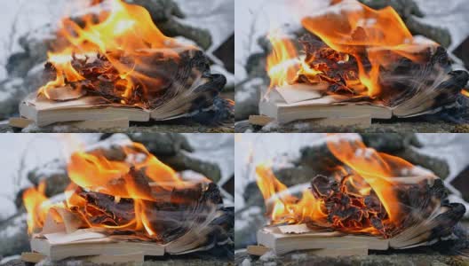 在石头和雪的背景下焚烧书籍高清在线视频素材下载