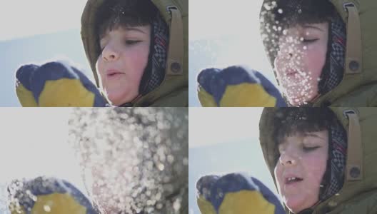 那男孩把手掌里的雪吹走高清在线视频素材下载