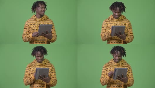 年轻快乐英俊的非洲男子使用数字平板电脑和思考高清在线视频素材下载