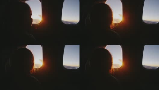 小女孩坐在飞机上，高兴地看着窗外冉冉升起的太阳高清在线视频素材下载