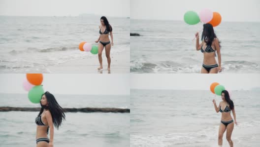 快乐的年轻女子在海滩上玩气球高清在线视频素材下载