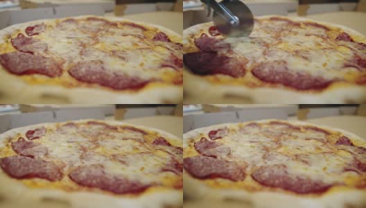 一个人用披萨刀把披萨切成多片的慢动作。特写镜头。高清在线视频素材下载
